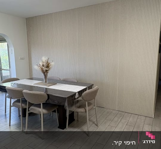 פינת אוכל מעוצבת עם ריצוף פנים באריחים מלבניים וקיר מחופה פאנלים דקורטיביים